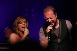 Zanger en zangeres zingen duet op jubileumfeest