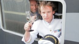 Man op boot tijdens 10 jarig jubileum bedrijf met glas champagne tijdens jubileum
