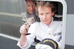 Man op boot tijdens 10 jarig jubileum bedrijf met glas champagne tijdens jubileum