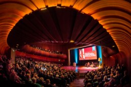 Keyvisual zaal overzicht ronding podium scherm 1 uai • jubileum • live-impact. Nl