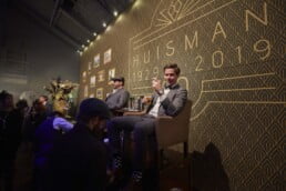 Man op stoel proost op jubileum bedrijf